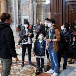 Un grupo de turistas con mascarillas visita la basílica de San Pedro ayer