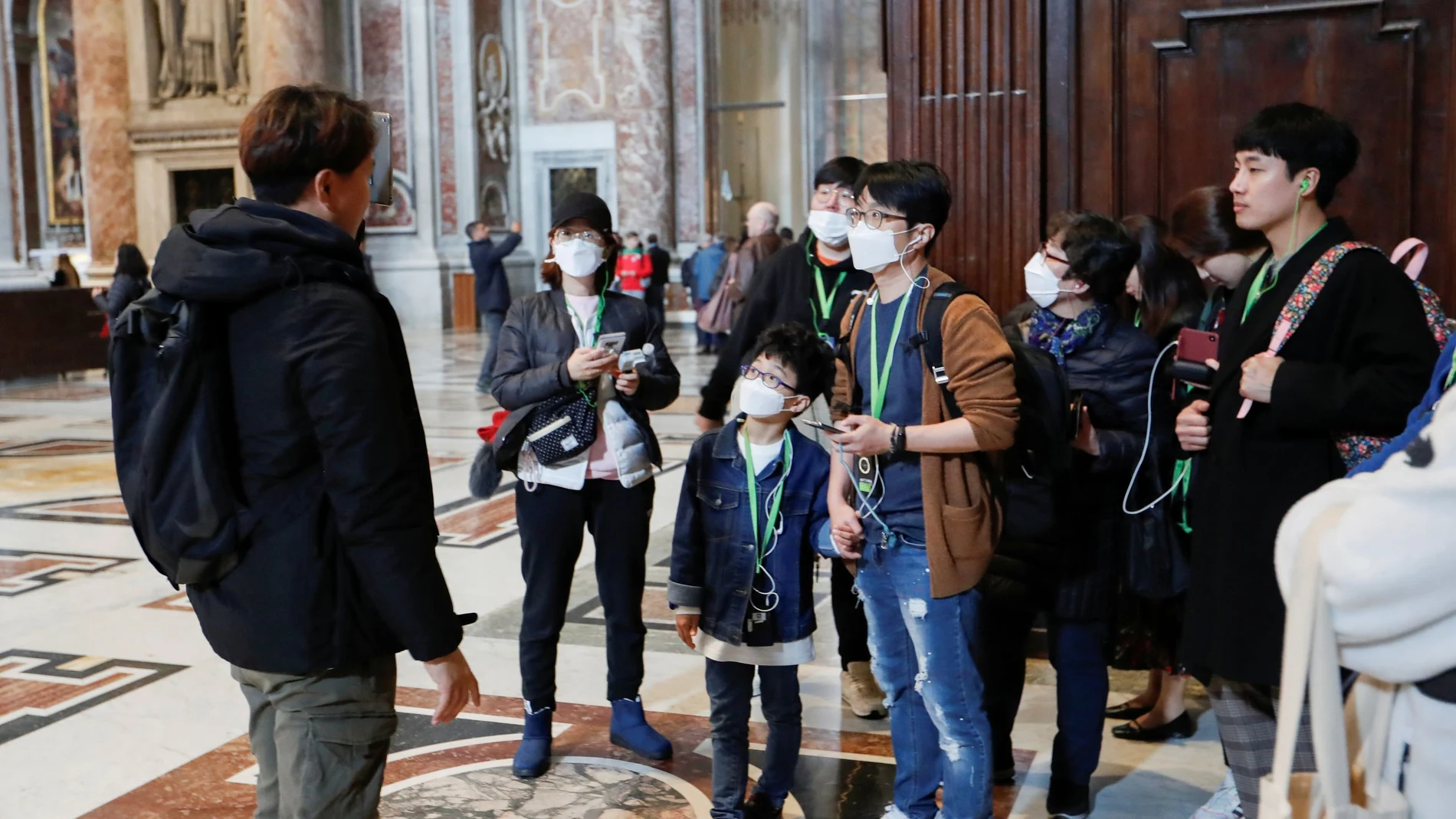 Tourists wearing protective face masks visit the St. Peter's Basilica, after the Vatican reports its first case of coronavirus, at the Vatican