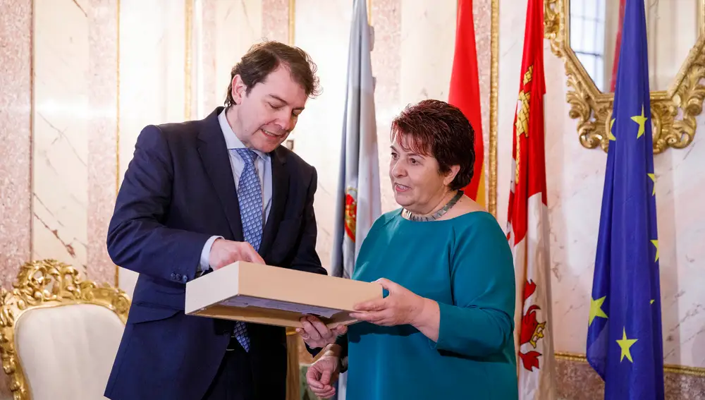 El presidente de la Junta recibe un obsequio por parte de la alcaldesa de Segovia, Clara Luquero, tras firmar en el Libro de Honor de la ciudad