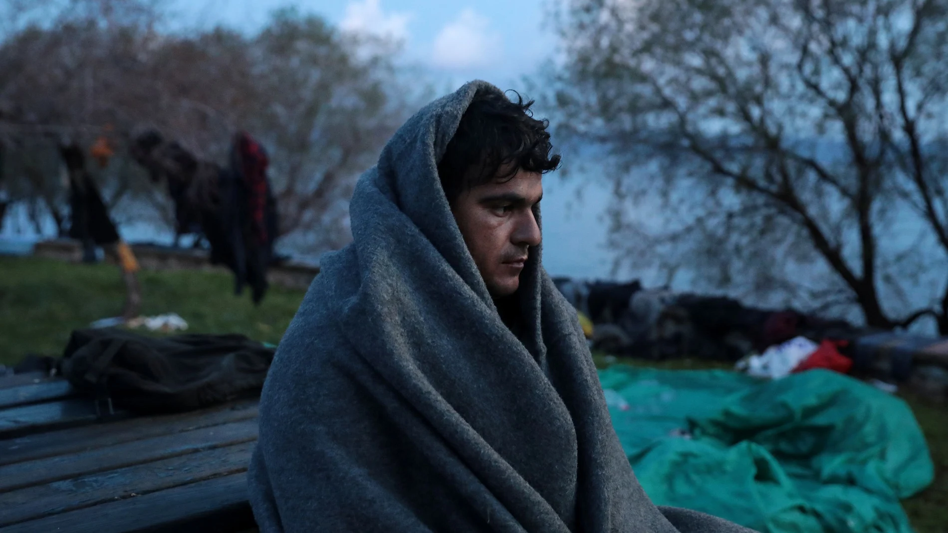 A migrant, who arrived the previous day on a dinghy after crossing part of the Aegean Sea from Turkey, is covered with a blanket near the village of Skala Sikamias, on the island of Lesbos
