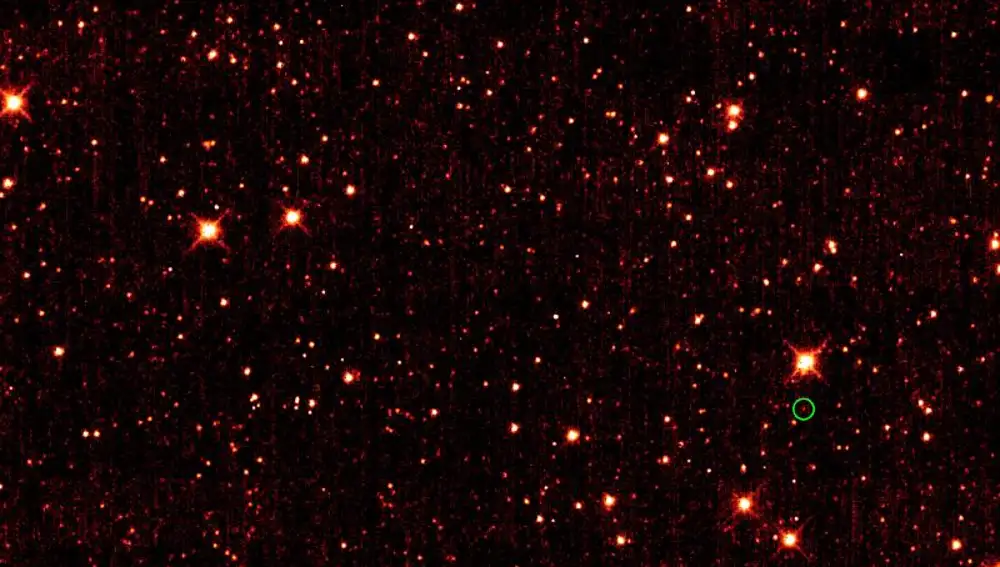 Fotografía infrarroja del cielo en la que aparece señalado el asteroide 2010 TK 7. El resto de luces más brillantes se corresponden con la emisión infrarroja de estrellas y galaxias lejanas.
