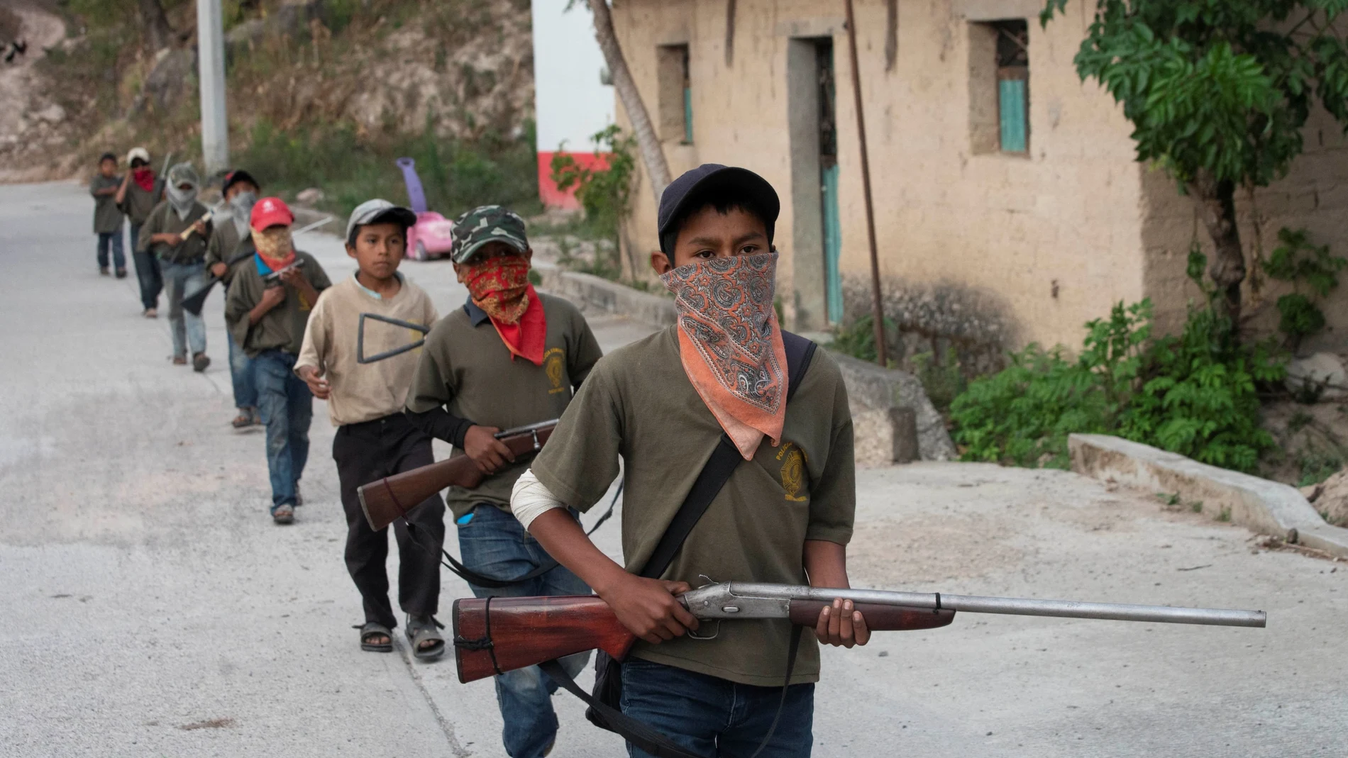 Una columna de niños portando armas en una localidad del estado de Guerrero, en México
