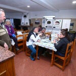 Varios peregrinos cenan en el albergue San Nicolás de Flüe de Ponferrada, junto a varios colaboradores del albergue