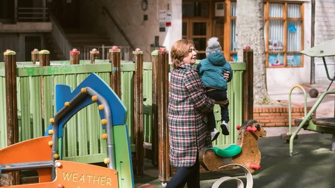 Una abuela cuida de sus nieto este martes en un parque de Vitoria / Efe