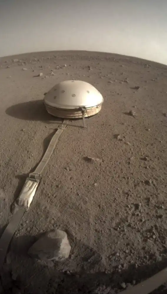 El sismómetro desplegado por la sonda InSight, cubierto por la cúpula que lo protege de las inclemencias de la atmósfera marciana.