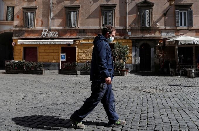 Un hombre con mascarilla camina por Roma en el tercer día de cierre total