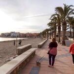 Mujeres pasean a sus perros en el paseo marítimo de la playa de Calabardina, en Águilas, Murcia