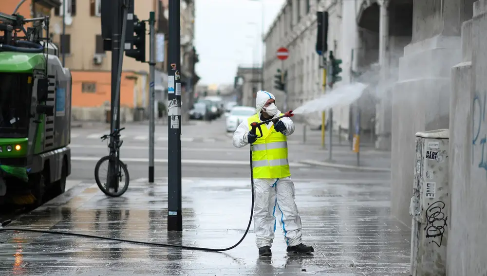 Un trabajador limpia y desinfecta las calles cerca de la estación central de Milán, en el cuarto día de un bloqueo sin precedentes en toda Italia impuesto para frenar el brote de coronavirus, en Milán, Italia, el 13 de marzo de 2020