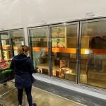 Una mujer mira la refrigeradora de pizza congelada casi vacía ayer en un gran supermercado