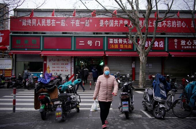 Una mujer con una mascarilla en el centro de Shanghái