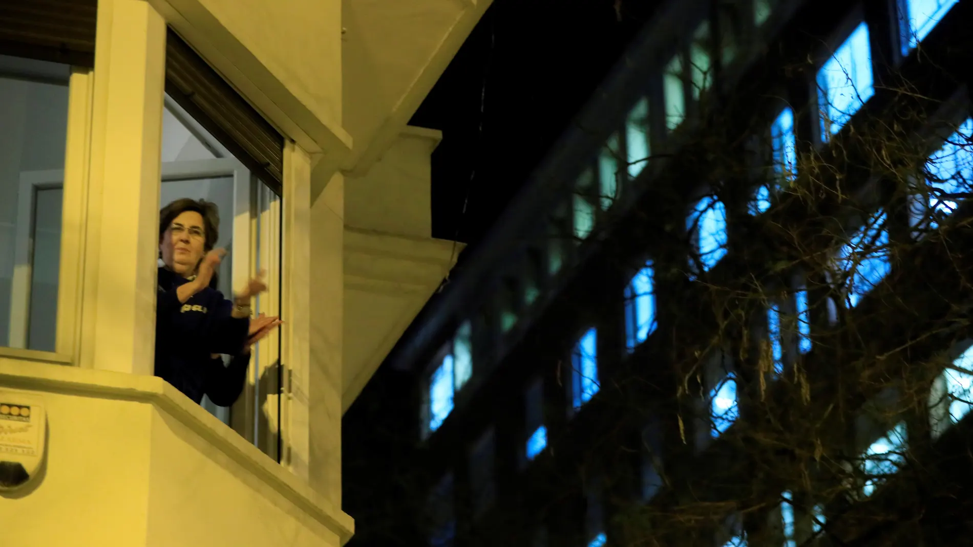 Una mujer aplaude esta noche desde la ventana de su casa en Madrid, secundando la convocatoria hecha en las redes sociales para hacer un homenaje a todo el personal sanitario que está trabajando para combatir el coronavirus en España. EFE/Fernando Alvarado