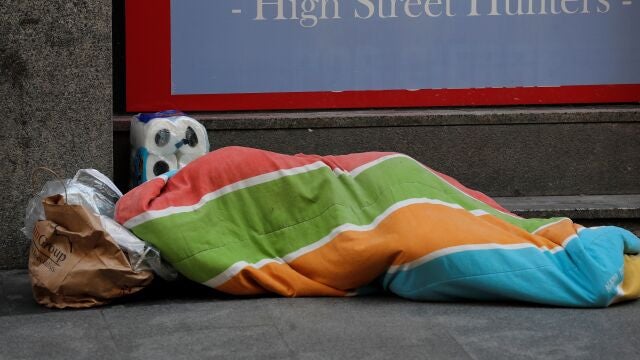 Una persona sin hogar duerme junto a su paquete de papel higiénico en los alrededores de la Puerta del Sol de Madrid . EFE/ Chema Moya