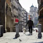 Un hombre pasea el pasado domingo a su perro en la Plaza Mayor de Madrid.