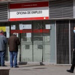 Dos ancianos leen los carteles de una oficina de empleo cerrada durante el estado de alarma en España