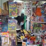 La dueña de un kiosko, uno de los pocos negocios que pueden abrir al público, se protege con mascarilla, hoy en Valencia