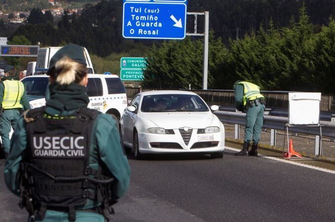 Efectivos de la Guardia Civil en un control de acceso instalado en el Puente Internacional de Tuy (Pontevedra), tras el anuncio de estado de alarma que hace que se hayan cerrado fronteras con Portugal a los viajes no imprescindibles. EFE/Salvador Sas
