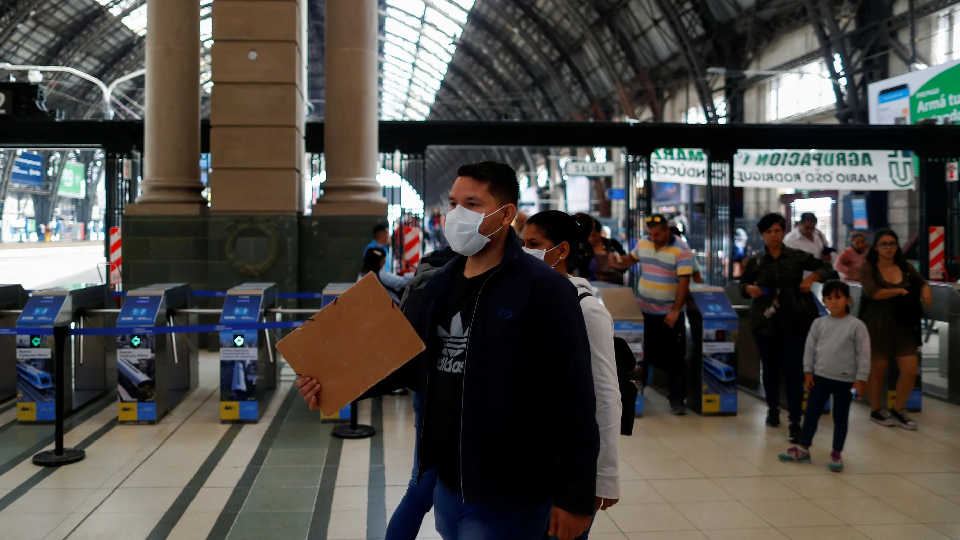 A man wearing a face mask as a preventive measure against the coronavirus outbreak walks at the Retiro train station, in Buenos Aires