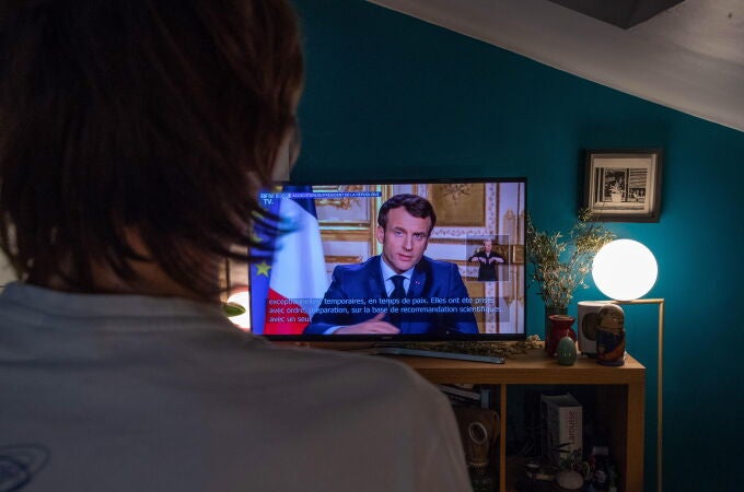 Un hombre ve el mensaje televisado del presidente francés Emmanuel Macron hoy lunes.