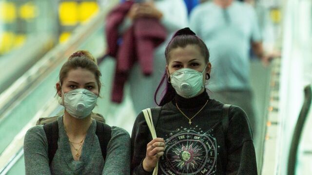 Dos jóvenes portando mascarillas