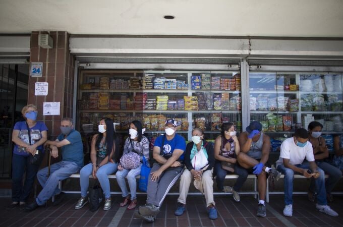 Venezolanos esperan a la puerta de una tienda de alimentación en Caracas