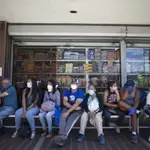 Venezolanos esperan a la puerta de una tienda de alimentación en Caracas