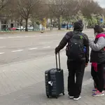 Dos turistas con maletas, uno de ellos con mascarilla, a su salida de la Estación de Atocha, durante el estado de alarma decretado por el coronavirus, en Madrid (España), a 16 de marzo de 2020.COVID-19;CORONAVIRUS;VIRUS;PANDEMIA;TURISMOJoaquin Corchero / Europa Press16/03/2020