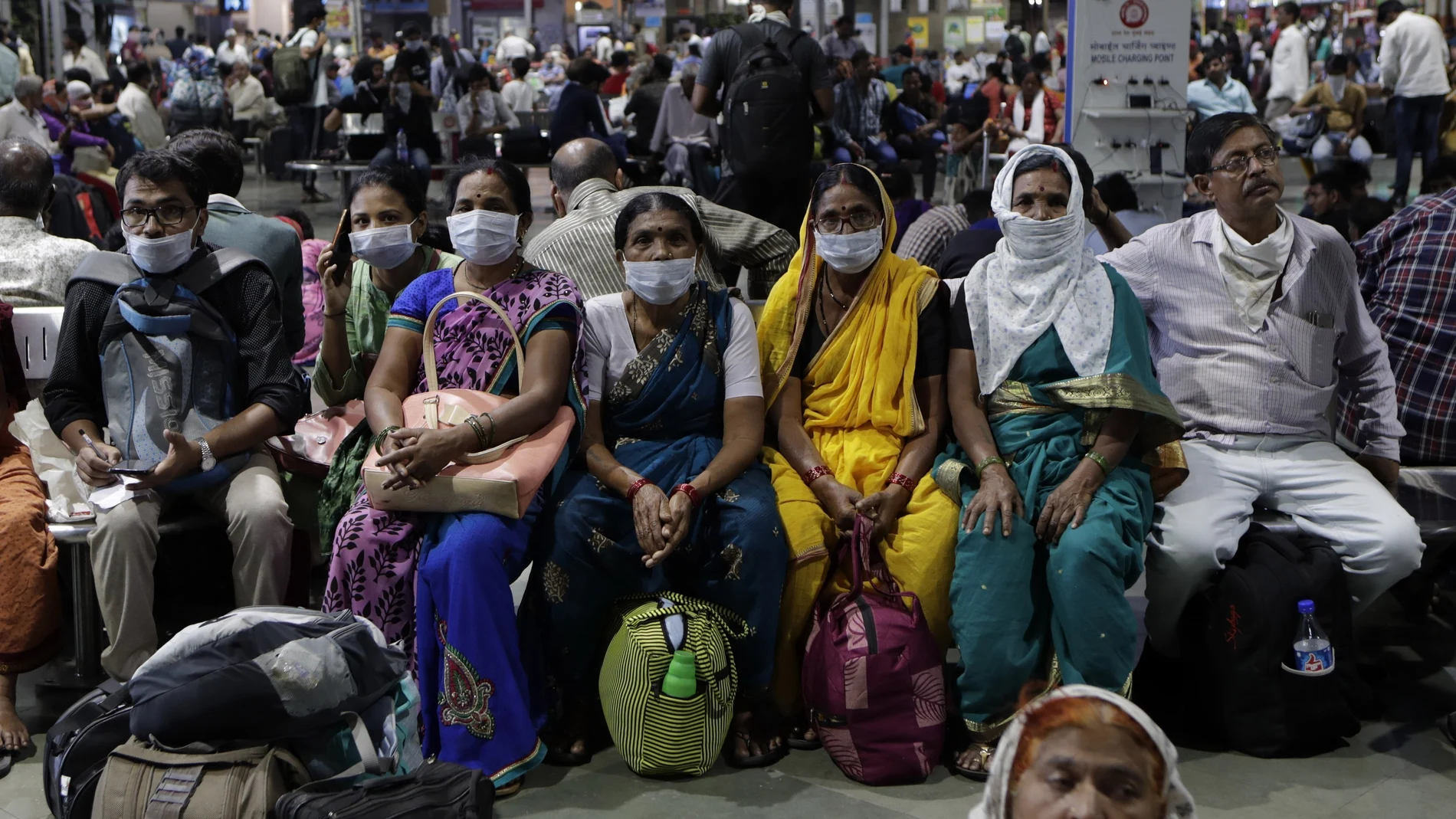 Una familia espera en una estación de Bombai