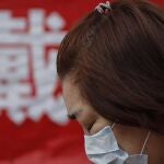 Una mujer se protege del coronavirus con una mascarilla, hoy en China