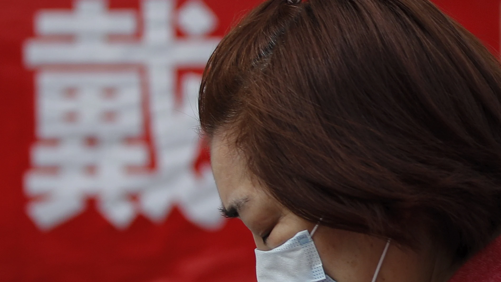 Una mujer se protege del coronavirus con una mascarilla, hoy en China