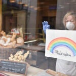 Una trabajadora de un establecimiento de comida se apoya en un cristal donde se puede leer en un cartel "Todo irá bien" como uno de los lemas del estado de alarma por el coronavirus en España