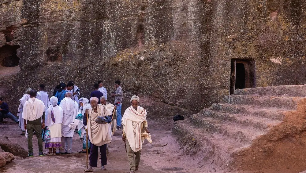 Grupo de fieles antes de entrar en uno de los templos de Lalibela. Pueden apreciarse los bastones de oración que alzarán repetidas veces al cielo durante el rezo.