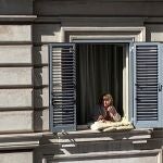 Maria y su perra Pepa salen a su ventana este jueves, como cada día, para combatir la soledad del aislamiento decretado por el coronavirus en Italia.