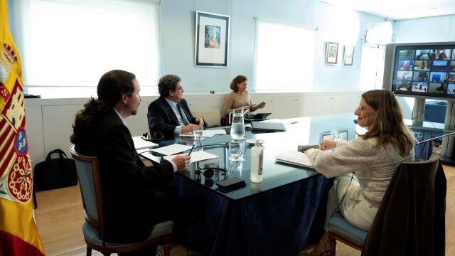 El vicepresidente segundo del Ejecutivo, Pablo Iglesias (i), junto a la ministra de Trabajo, Yolanda Díaz (d); y el ministro de Inclusión, Seguridad Social y Migraciones, José Luis Escrivá (c)