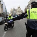 GRAF9231. MADRID, 19/03/2020.- Policías municipales montan un control en la calle Alcalá, este jueves, en Madrid. La epidemia sigue su ascenso imparable en España con más de 2.500 nuevos casos comunicados el miércoles, que elevan a cerca de 14.000 el número de infectados diagnosticados, y más de 600 fallecidos. EFE/Kiko Huesca