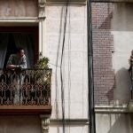 Dos vecinos conversan en el balcón de sus casas en Madrid