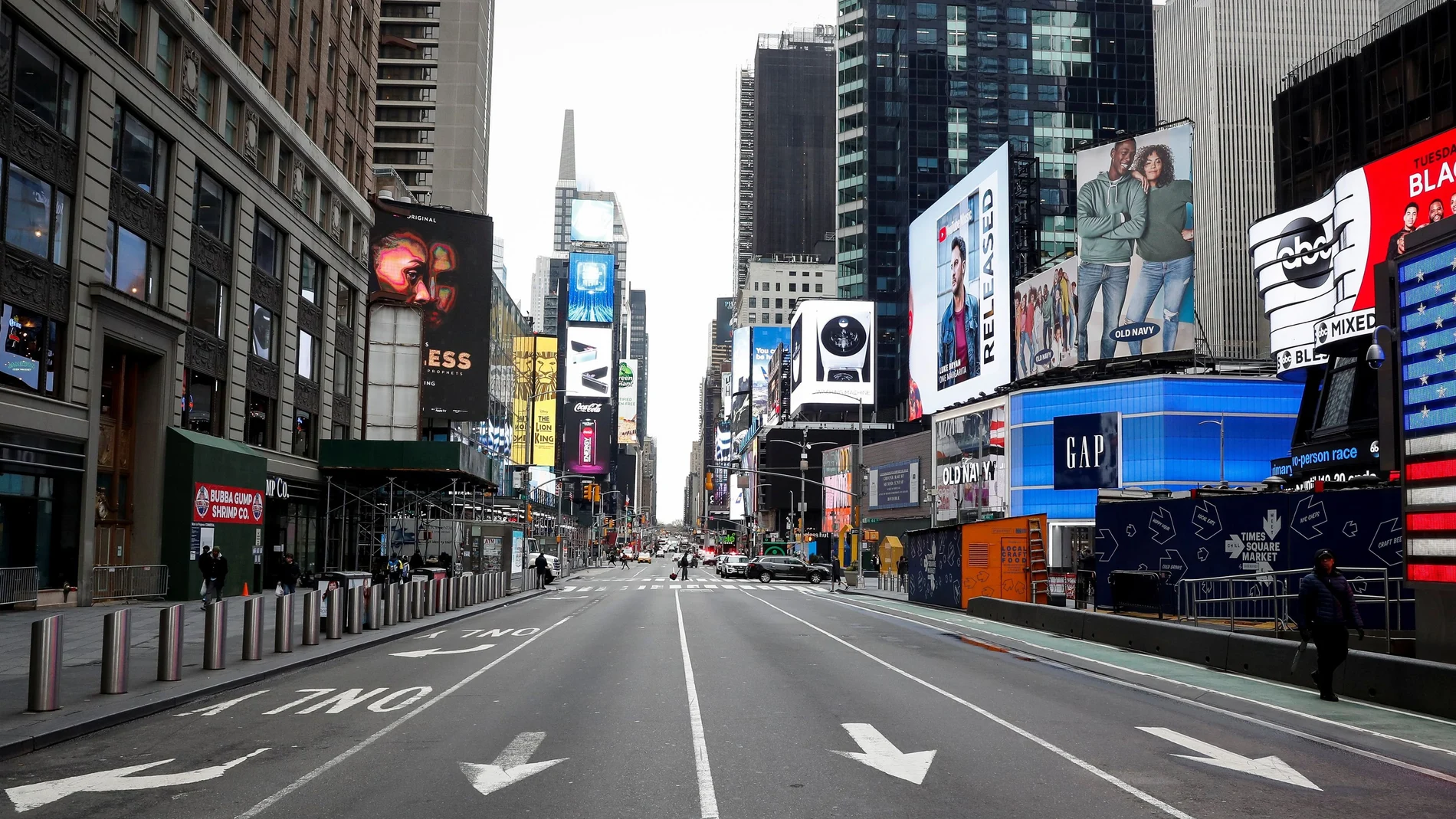 FILE PHOTO: People walk through a nearly empty Times Square, during the outbreak of coronavirus disease (COVID-19) in New York