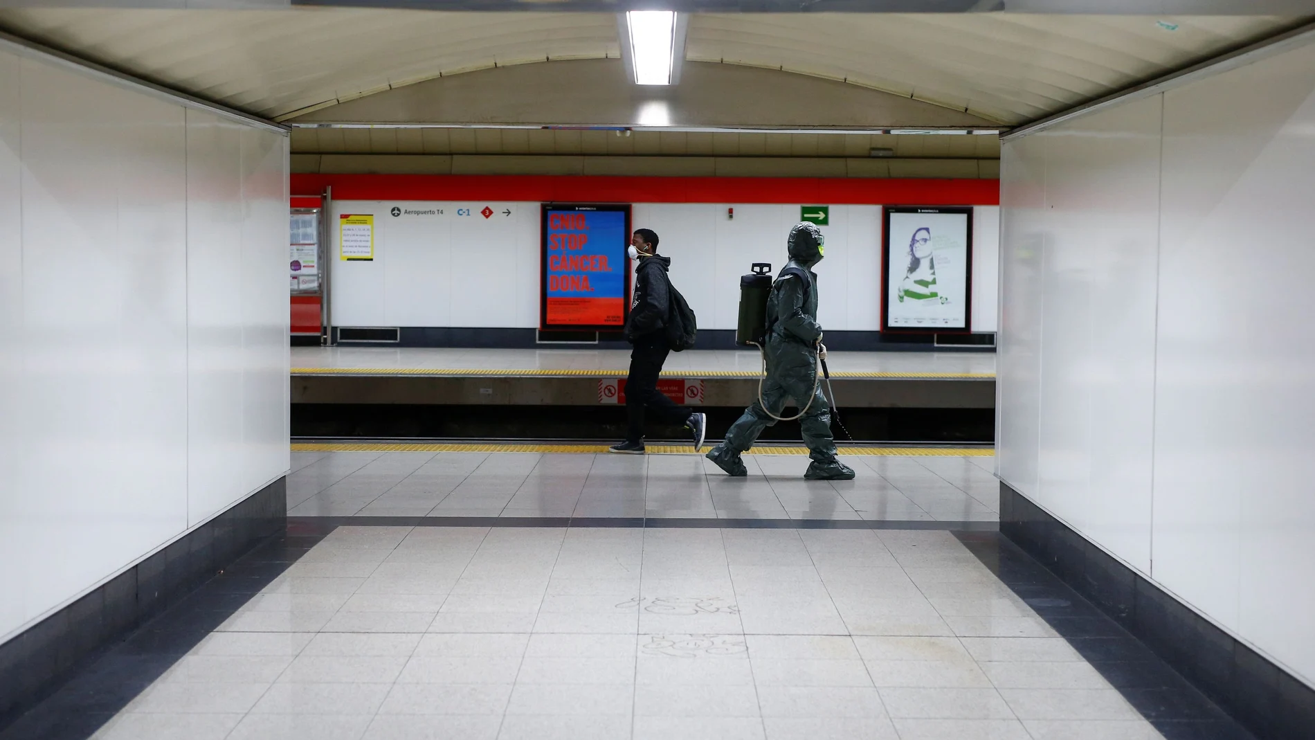A Military Emergency Unit member disinfects Nuevos Ministerios metro station during a partial lockdown as part of a 15-day state of emergency to combat the spread of coronavirus disease (COVID-19) in Madrid