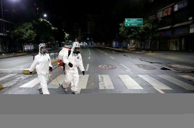 Dos trabajadores en labores de desinfección en el centro de Caracas
