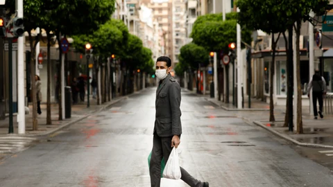 Una persona con mascarilla recorre las calles de Murcia, vacías durante el estado de alarma, con bolsas de plástico en las manos, en Murcia (España) a 22 de marzo de 2020.22-03-20 CALLES VACIAS EN MURCIA POR EL CORONAVIRUS COVID 19 CALLE ALEJANDRO SEIQUEREdu Botella / Europa Press22/03/2020