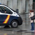 Un agente de la Policía Nacional dentro de un coche habla con una mujer que camina por la céntrica calle de Preciados, prácticamente vacía durante el inicio de la segunda semana del estado de alarma por coronavirus, en Madrid (España) a 23 de marzo de 2020.PANDEMIA;COVID-19;Joaquin Corchero / Europa Press23/03/2020