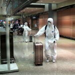Taoyuan City (Taiwan), 23/03/2020.- A man and a woman, wearing protective gowns, return from Combodia, arrive at Taoyuan International Airport in Taoyuan, northern Taiwan, 23 March 2020. On 23 March, Taiwan reported 26 new coronavirus Covid-19 infection cases, pushing the total to 195. Of the 26 cases, 25 are 'imported cases.' EFE/EPA/DAVID CHANG