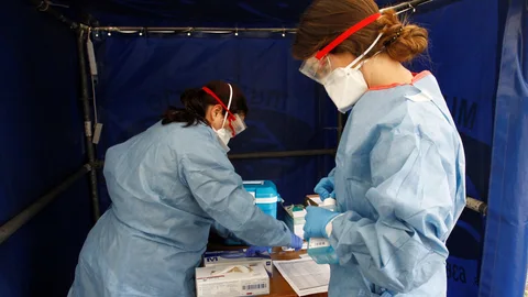 Dos enfermeras toman muestras de detección del coronavirus