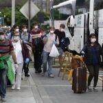 Ciudadanos españoles esperan los autobuses que los llevarán al aeropuerto a tomar un avión de repatriación de Iberia el miércoles