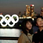 Una pareja se saca un selfie en Tokio con la escultura de los anillos gigantes de fondo