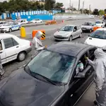 Policías iraníes bloquean una autopista en las afueras de Teherán para hacer controles de posibles contagios