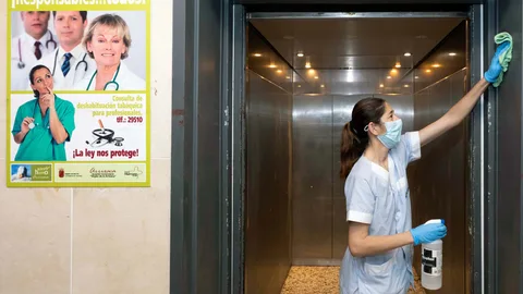 Una limpiadora desinfecta el ascensor del hospital Virgen de la Arrixaca