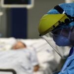 Un sanitario protegido con un traje especial entra en la habitación de un enfermo de coronavirus hospitalizado en Bruselas/REUTERS