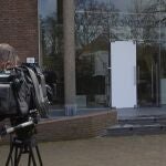 A cameraman films the glass door which was smashed during a break-in at the Singer Museum in Laren, Netherlands, Monday March 30, 2020. Police are investigating a break-in at a Dutch art museum that is currently closed because of restrictions aimed at slowing the spread of the coronavirus, the museum and police said Monday. (AP Photo/Peter Dejong)