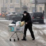Un hombre protegido con una máscara empuja un carro de la compra en una calle de Moscú/EFE