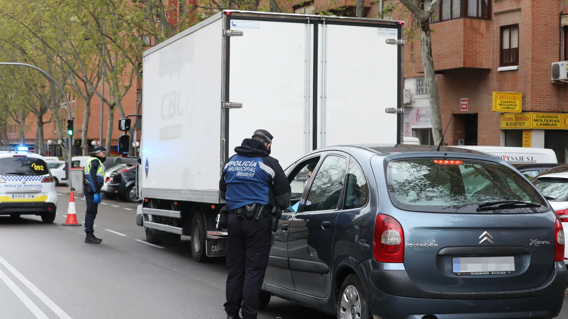 Dos policías municipales le piden la documentación a los conductores de dos vehículos